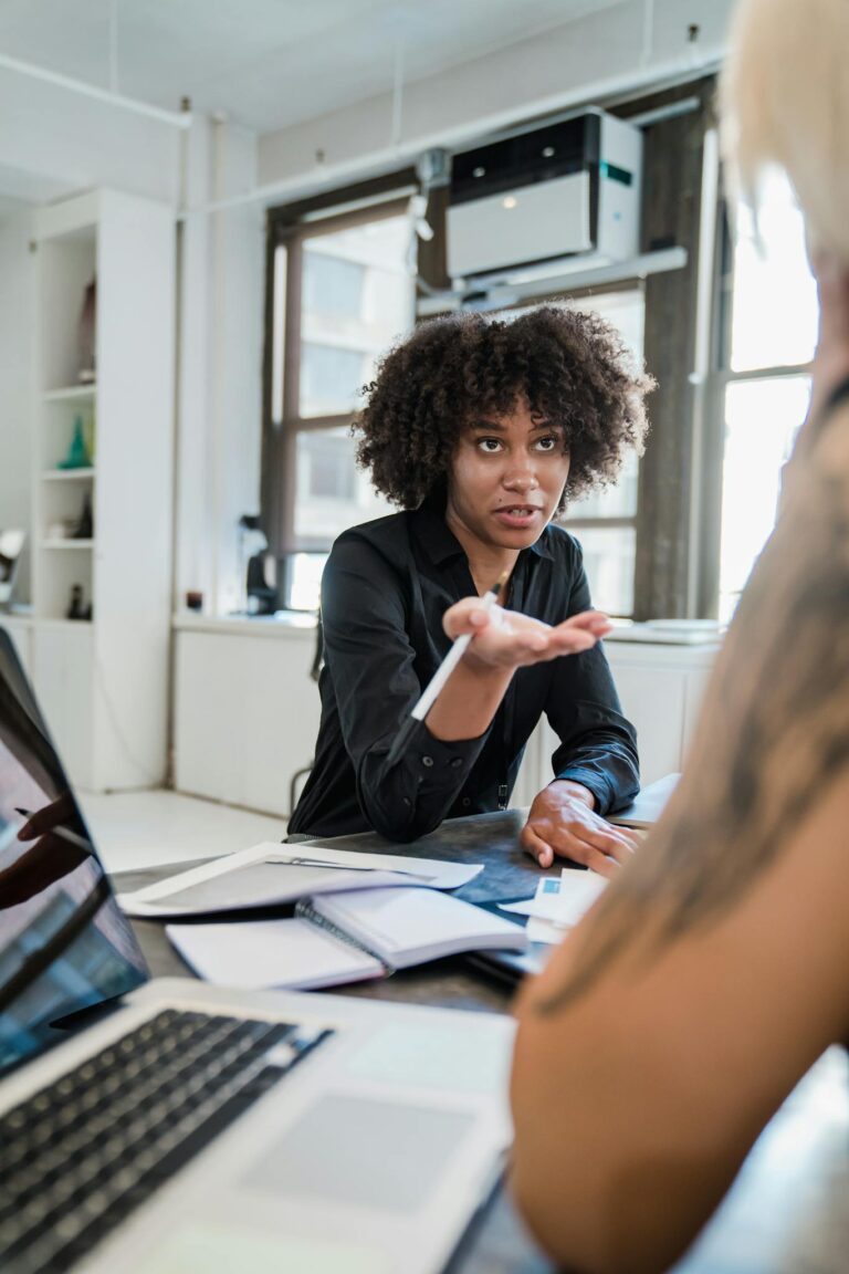 A professional woman engaged in a serious discussion inside a contemporary office environment.