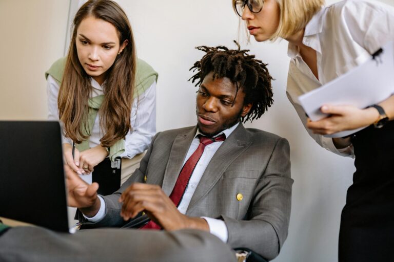 Three diverse colleagues engaged in a collaborative brainstorming session in an office.
